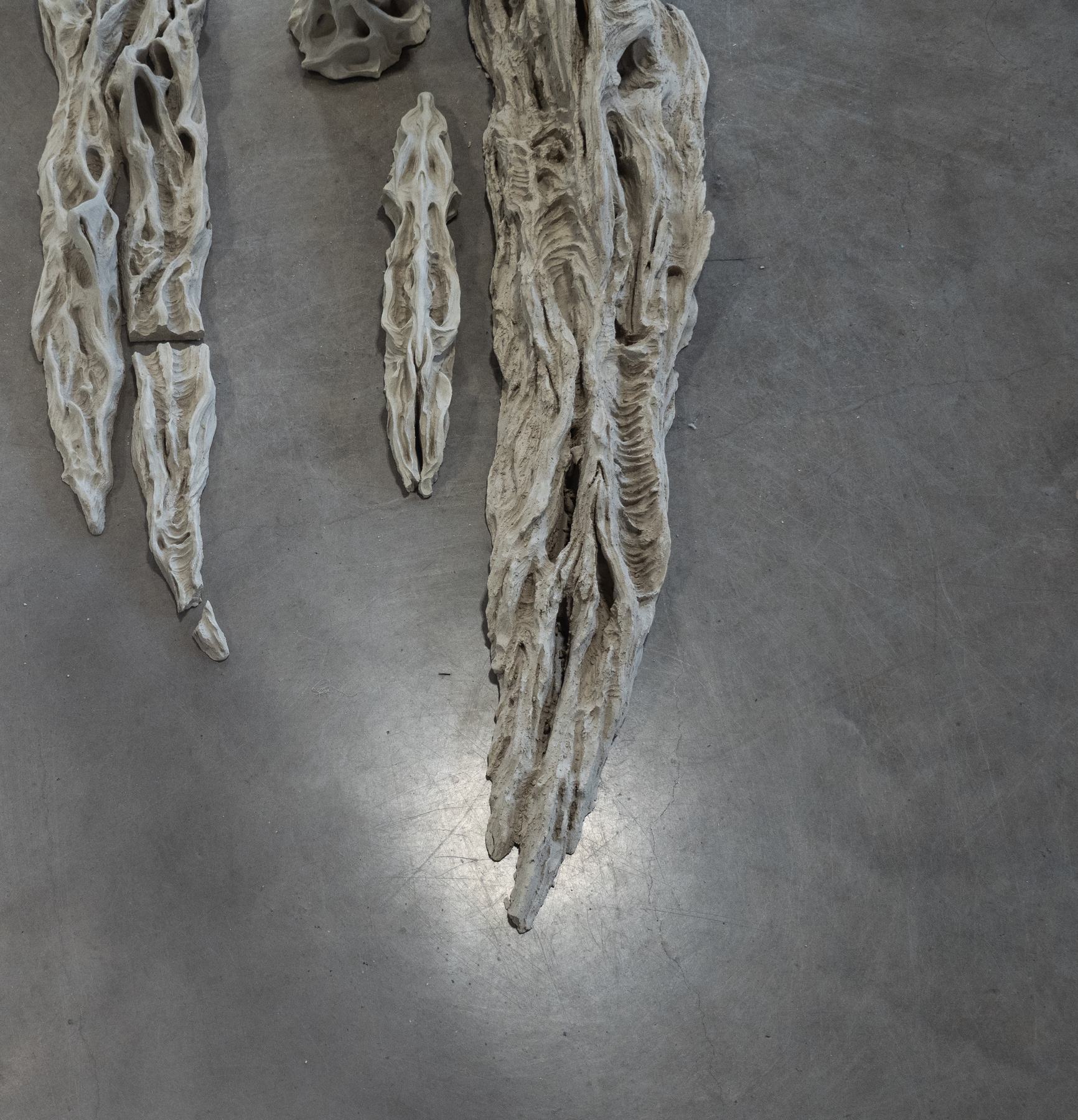 Ceramic forms arranged on a floor.